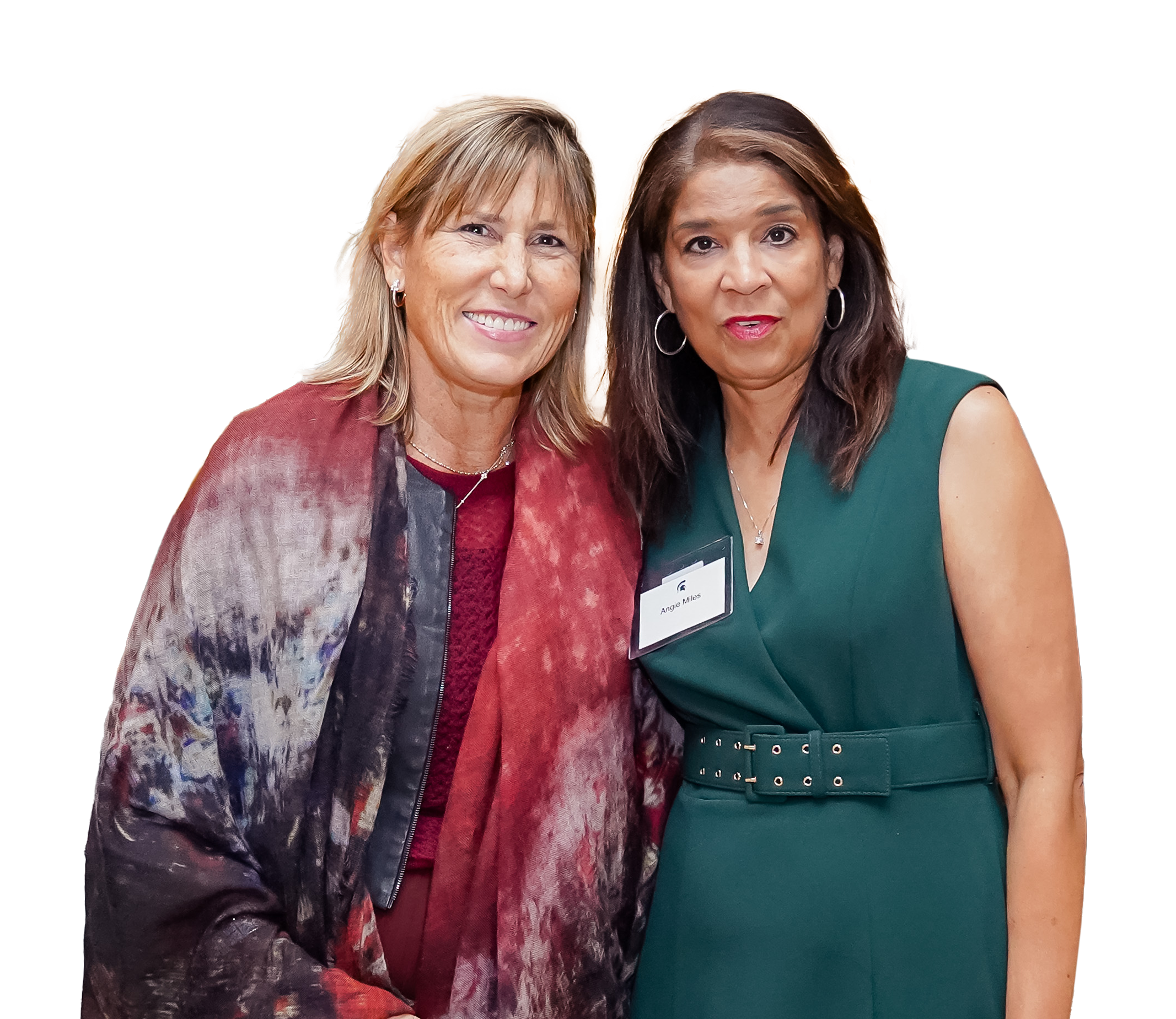 Two women standing closely next to eachother and smiling to the camera.